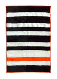 A minimalist striped rug in black and white sheepskin, with a stunning orange accent stripe. 